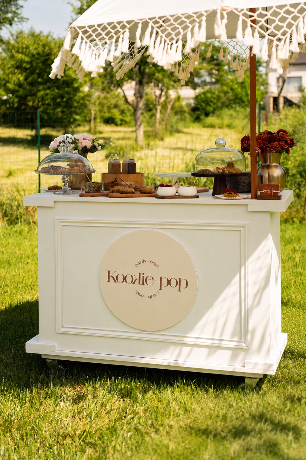 Bar à cookies Kookie-Pop installé en extérieur avec parasol à franges